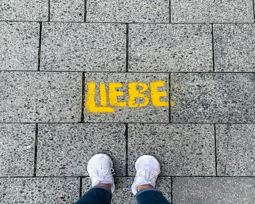Legs of a person wearing casual shoes taking a relaxing walk on a paved sidewalk